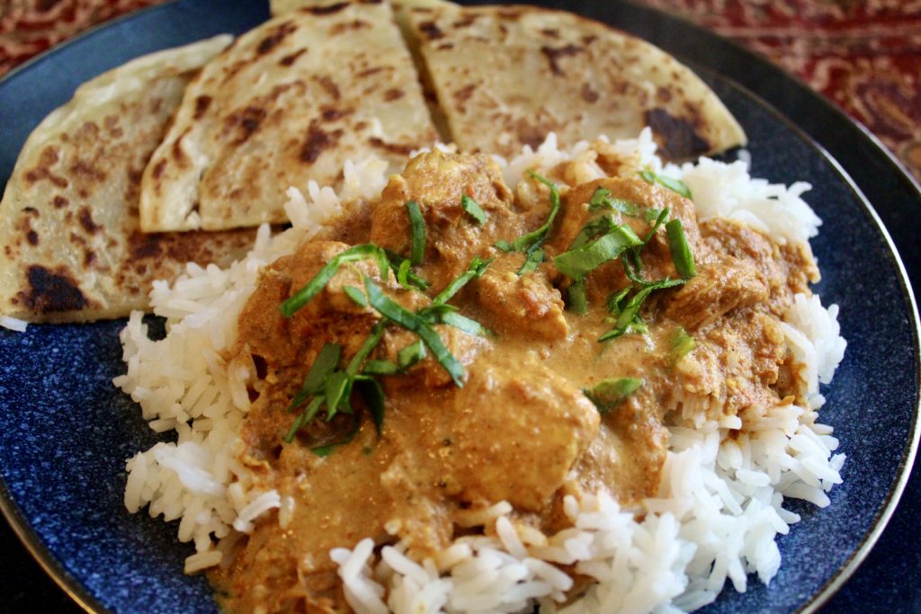 plate of Instant Pot Butter chicken on rice with naan bread