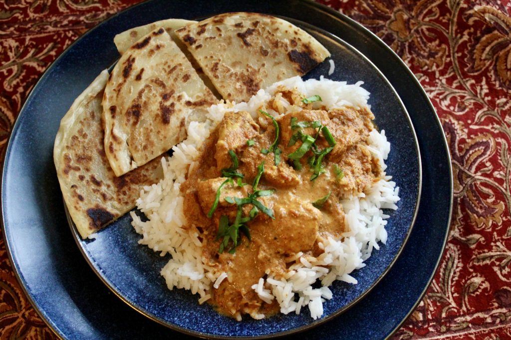 plate of Instant Pot Butter chicken on rice with naan bread