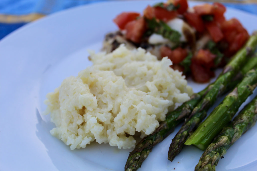 Plate of creamy parmesan rice with asparagus and bruschetta chicken
