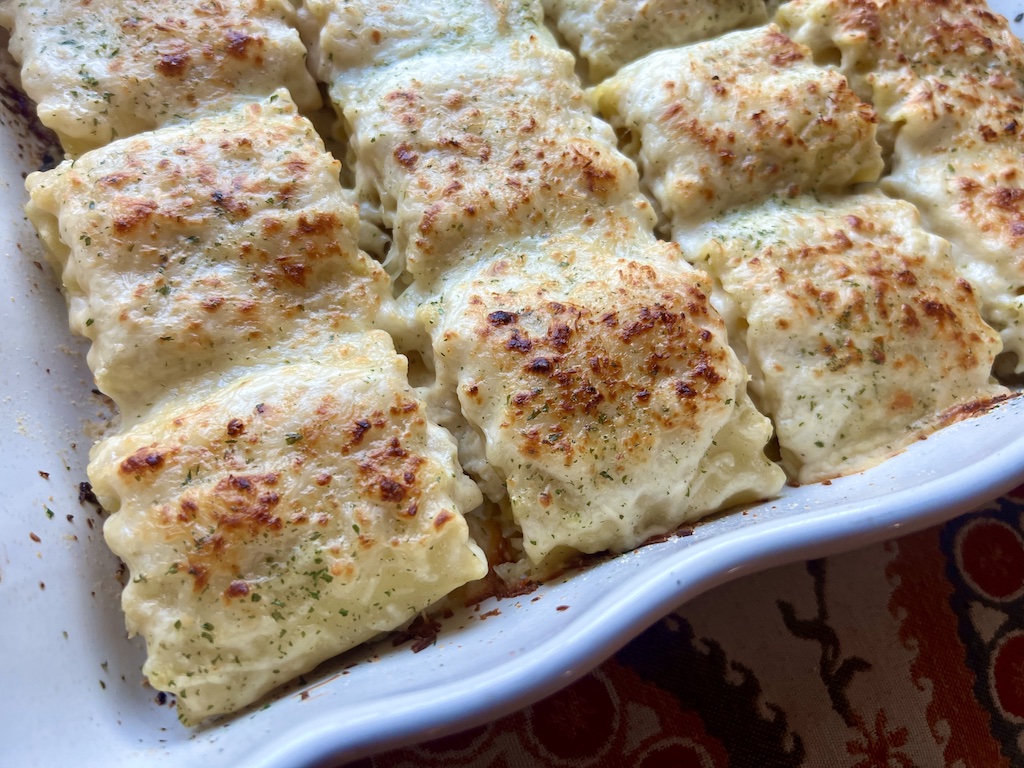 pan of chicken Alfredo lasagna rolls ups out of the oven.