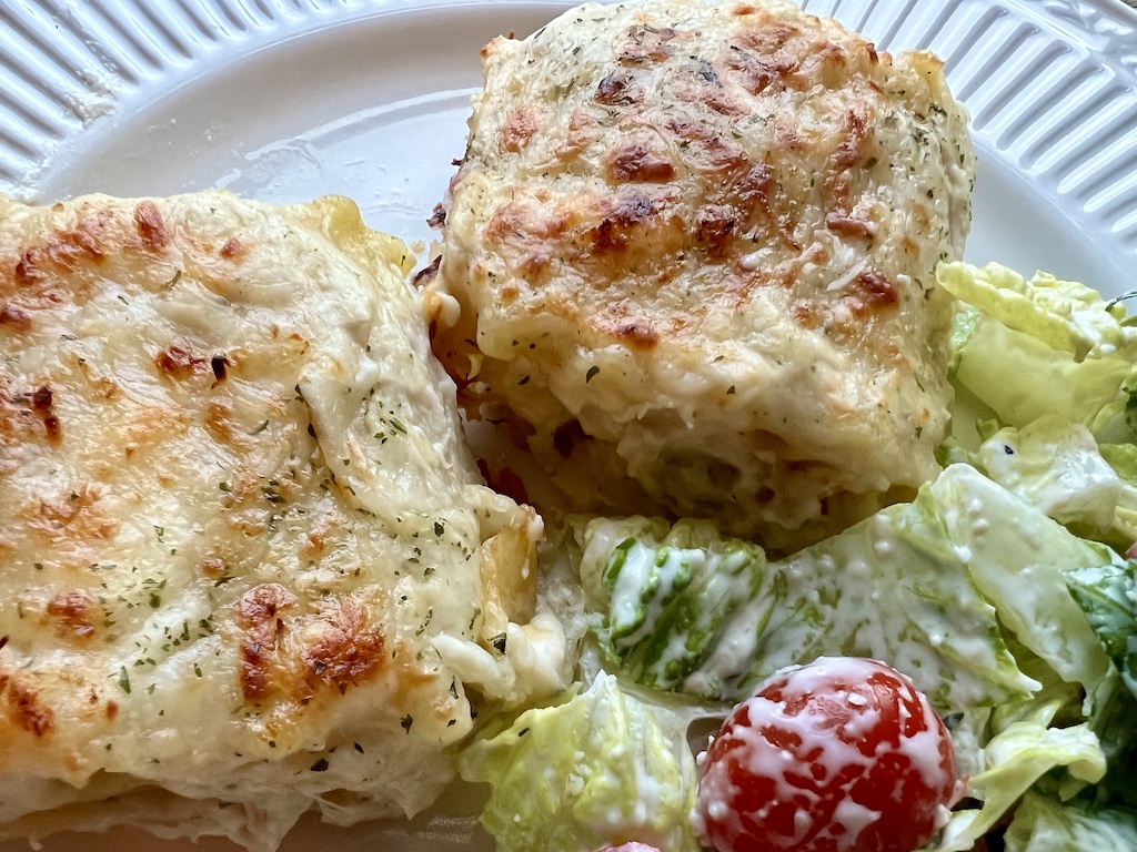 close up picture of a serving of chicken Alfredo lasagna roll ups